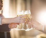 Close-up of group of businesspeople toasting glasses of champagne in t